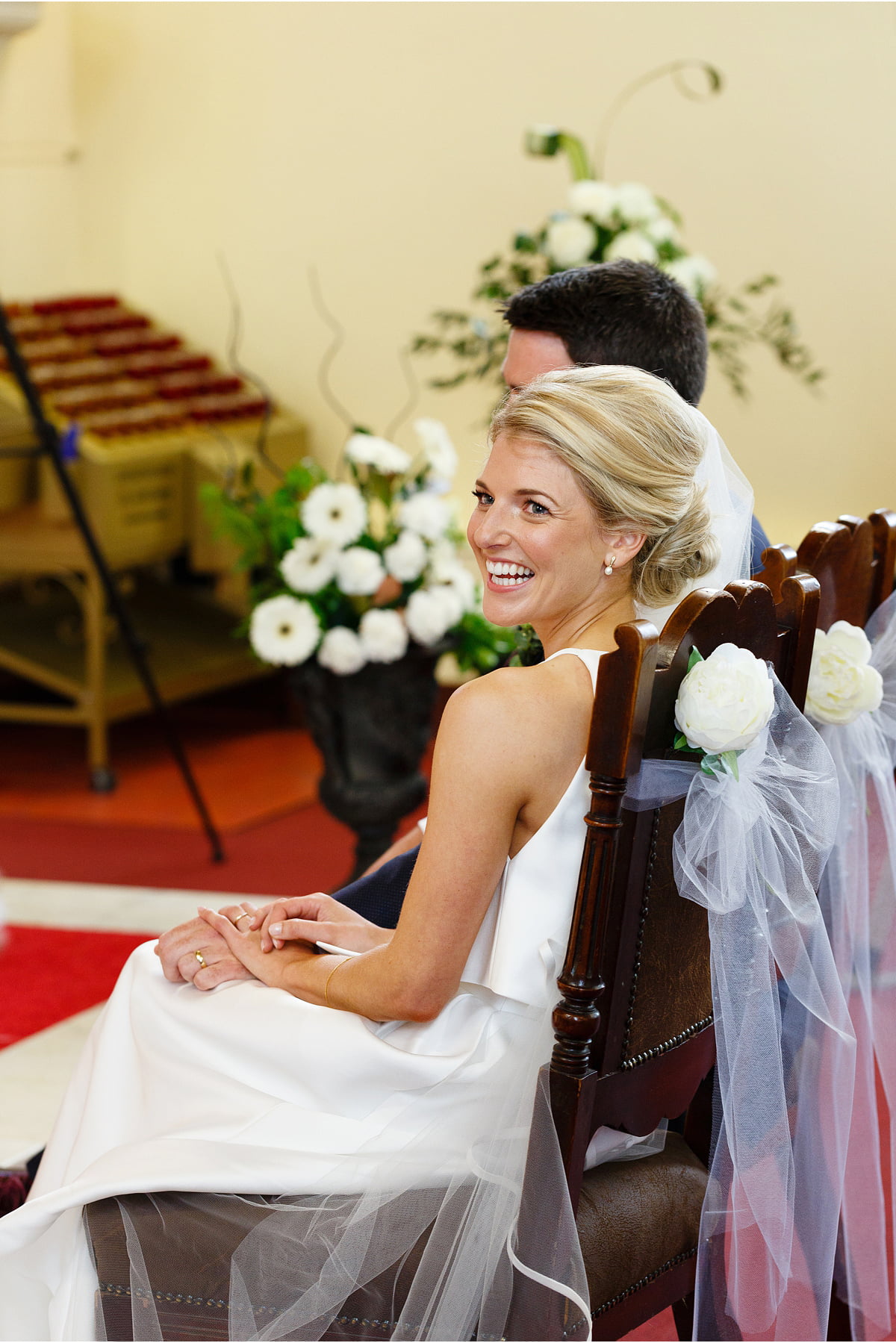 beaming bride glances over her shoulder during wedding cerrmony