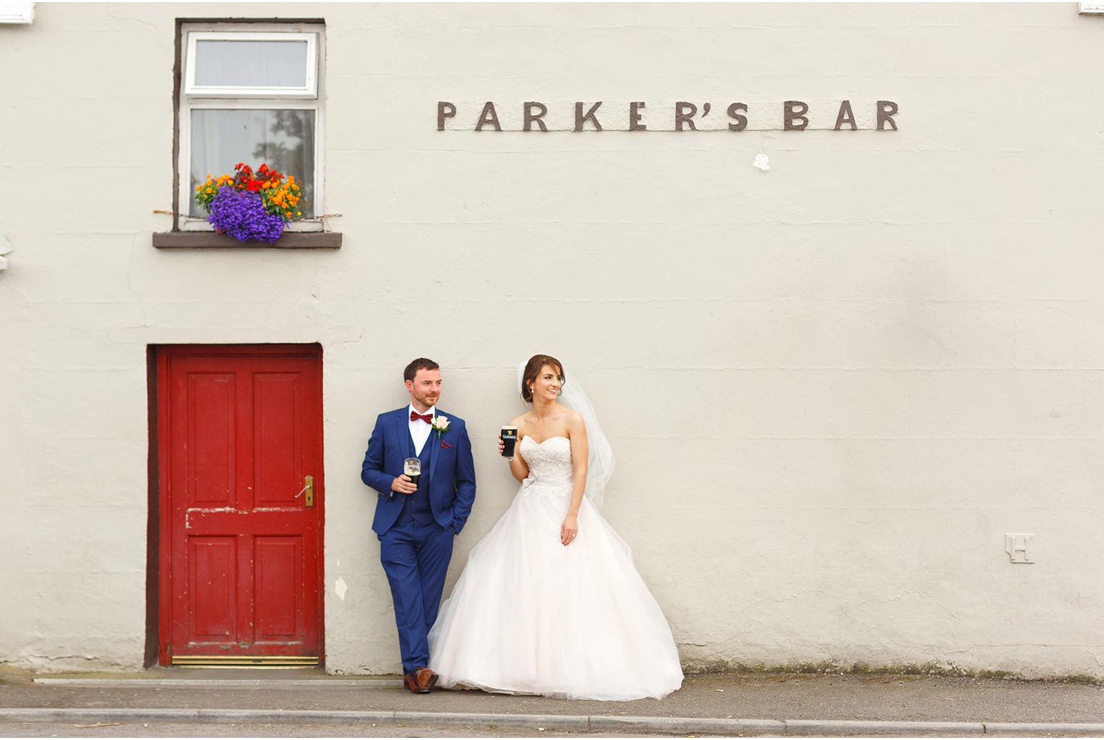 bride and groom have a pint of guiness outside parkers bar in Kilflynn Co Kerry
