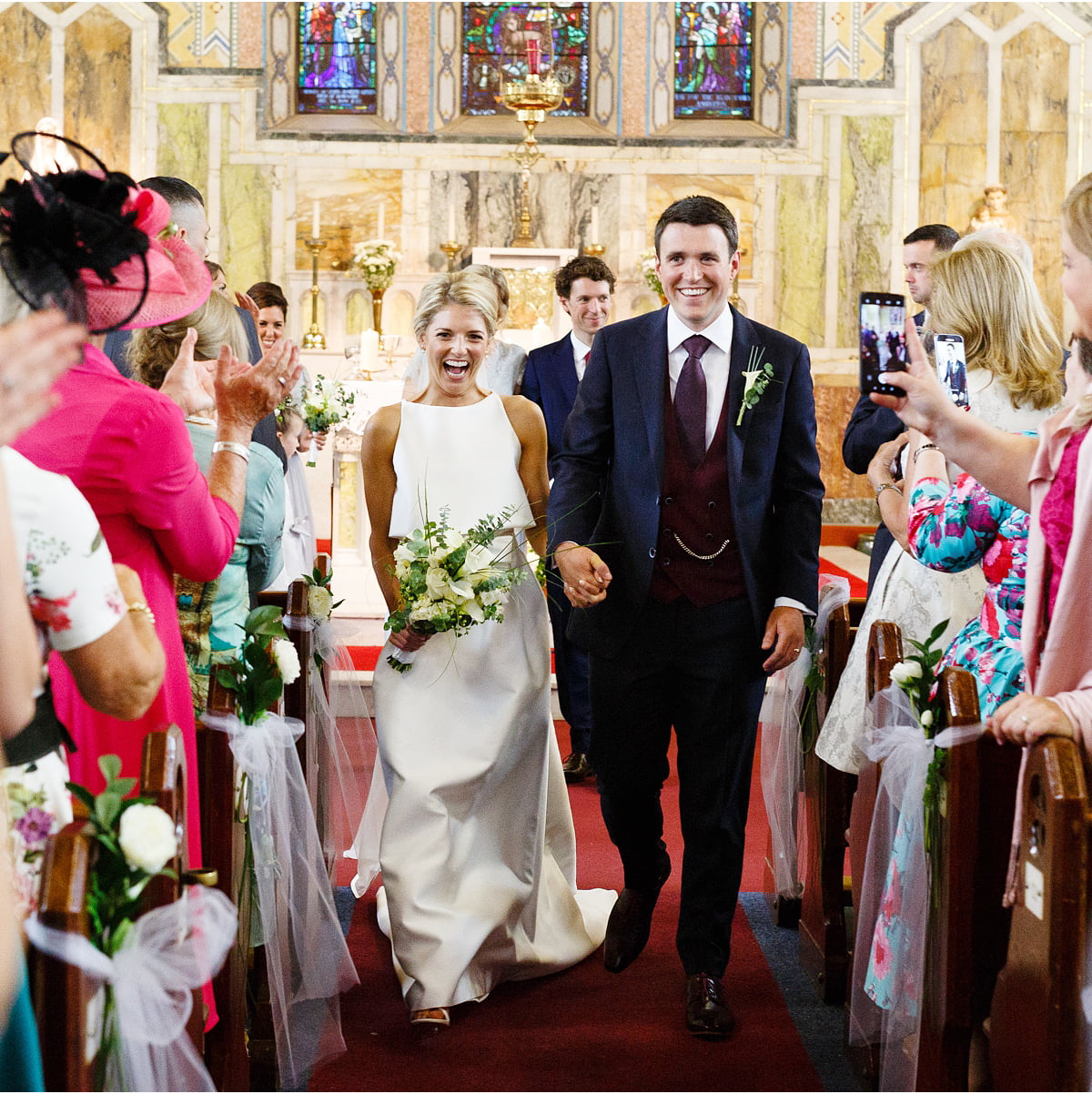 newly married couple walk down the isle together