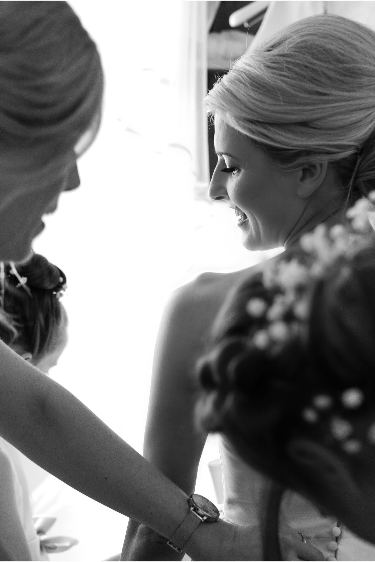 black and white photograph of bride getting dressed