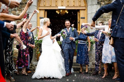 bride and groom are showered with confetti at their wedding in Waterford Castle