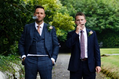 groom and best man puff on cigars at wedding in Waterford castle