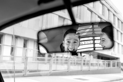 bride and groom caught in the reflection of the rear view mirror on their way to the wedding reception in the River Lee Hotel Cork