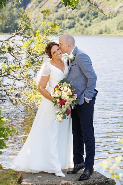 Groom kisses bride at a Summer wedding in Gouganne Barra in West Cork