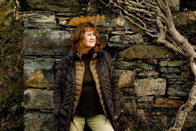 portrait of Kate Bennett by stone wall. profile photographs for about section of website