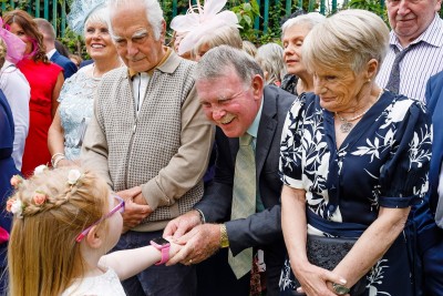 bunch of elderly wedding guest shake hand of little girl
