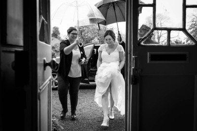 bride arrives at her wedding in Cloughjordan House in the rain
