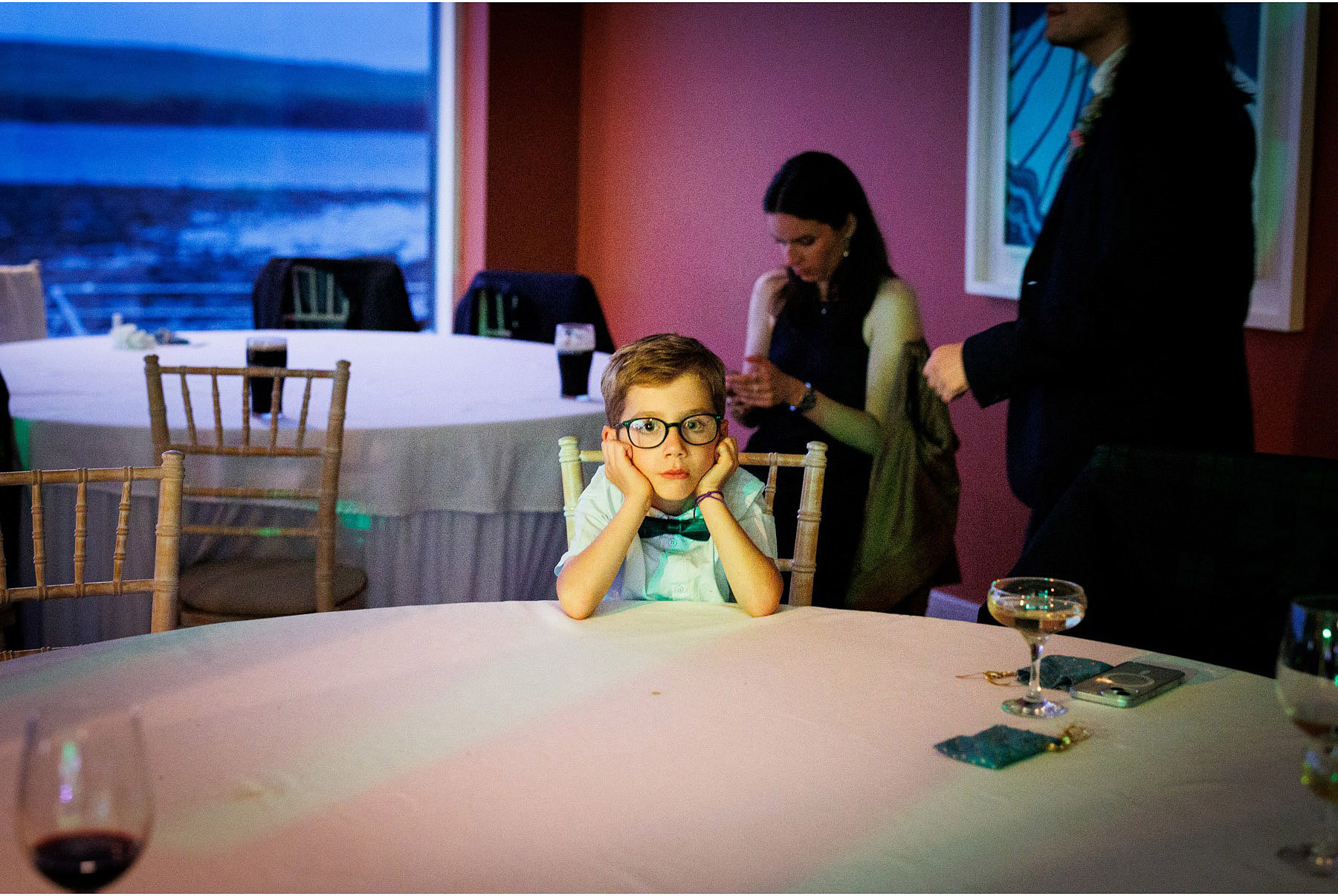 bored little boy stares at photographer at wedding in Diamond Rocks in Kilkee
